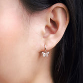 Fine jewellery, silver jewellery, hypoallergenic, tarnish-free, close-up front view of a Butterfly-shaped earring worn by a person with dark hair.